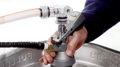 A man's hands connecting a drinks dispense valve to a beer keg.