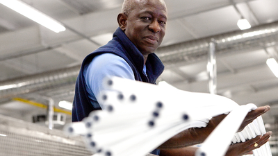 A man holding JG Speedfit pipes in the production factory.