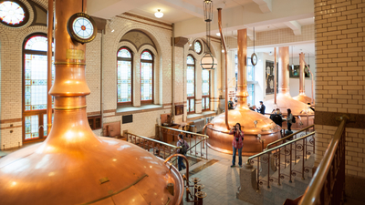 Huge copper vessels brewing beer at the Heineken brewing bar.