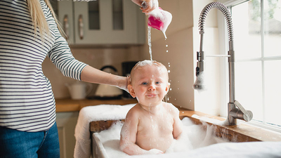 Baby having bath in sink