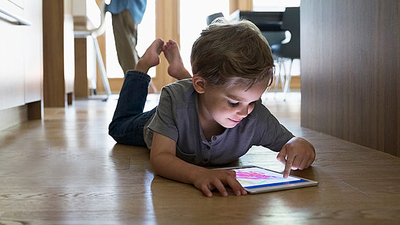 A boy using a tablet on a heated floor
