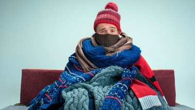 Man, indoors wrapped up in layers